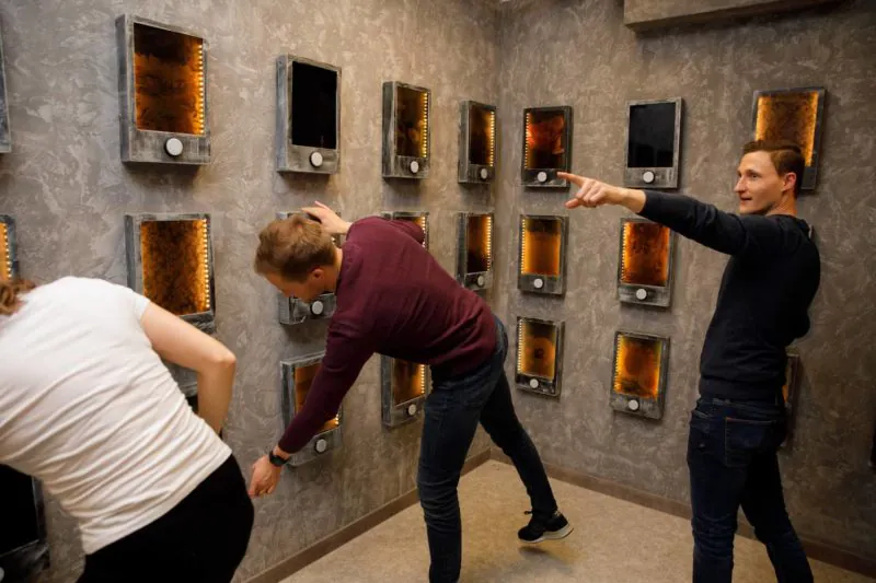 Team sucht die richtigen Felder an einer Wand mit beleuchteten Kästen